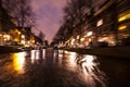 Night lighting reflections in Amsterdam channels from moving cruise boat. Blurred abstract photo as background.