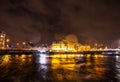 Night lighting reflections in Amsterdam channels from moving cruise boat. Blurred abstract photo as background.