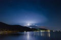 Night lightning strike over mountains resort with star at the Khanom beach of Thailand. Royalty Free Stock Photo