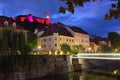 Night lights landscape of old city. Illuminated medieval buildings near Ljubljanica River and ancient Ljubljana Castle at the top Royalty Free Stock Photo