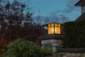 Night lights in the park. Latern glow in night garden. Dark street at night with light of latern shining on the wall