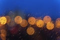 Night lights of urban traffic, wet window in rainy weather. Abstract background for banner design. Night city life, cars Royalty Free Stock Photo