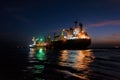 Night loading big mother sea bulk carrier ship with Bauxite aluminium ore from the mini bulk carrier feeder vessel at offshore