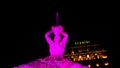 Night long exposition of the triton of the homonymous fountain lit with pink headlights