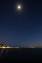 Night long exposure of the sky with the bright moon and stars over the sea Royalty Free Stock Photo