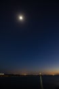 Night long exposure of the sky with the bright moon and stars over the sea Royalty Free Stock Photo