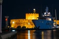 night Marina port Mandraki Rhodes island with a large yacht at the pier on background of the ancient fortification, the middle Royalty Free Stock Photo