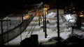 Night motion photo of a train passing a train station in winter. Electrified railway track. Royalty Free Stock Photo