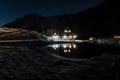 Night mountain landscape with illuminated blue tent. Mountain peaks and the moon. outdoor at Lacul Balea Lake, Transfagarasan, Royalty Free Stock Photo