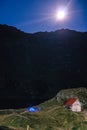 Night mountain landscape with illuminated blue tent. Mountain peaks and the moon. outdoor at Lacul Balea Lake, Transfagarasan, Royalty Free Stock Photo