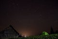 Night mountain landscape with illuminated tent. wooden house and starry sky Royalty Free Stock Photo