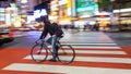 Night panning photography of unidentified man riding bicycle at Shibuya Square.The one of the wor