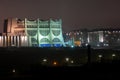 Night panorama of the big city at the foot of the river. Lots of colorful burning lights and street lighting. Top view of houses