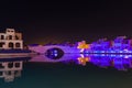 Night panorama from coast in Limassol, Cyprus island, Mediterranean Sea. Colourful bridge and buildings with reflection in water