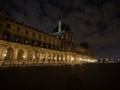 Night panorama of old historic exterior facade at Louvre pyramid architecture museum building in Paris France Europe