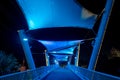 Night photo of a neon blue pedestrian walkway over a road