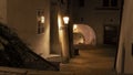 Night photo from the stairs to the dark arcade with the reflection of an old lamp in the window