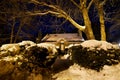 Night photo of the winter view of a cozy little house strewn with snow and festive lights. Royalty Free Stock Photo