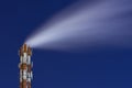 Night picture of a steaming pipe of smoking factory chimney system against a dark starry sky. Abstract Industrial