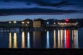 Night pier with colorful reflections on water and cloudy sky background Royalty Free Stock Photo