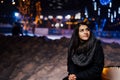 Night portrait of a beautiful brunette woman smiling enjoying winter in park.Winter joy.Winter holidays.Positive emotions.