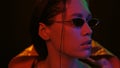 Night portrait of girl and neon lights. Portrait shot of a beautiful girl wearing down jacket and sunglasses in neon Royalty Free Stock Photo