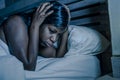 Night portrait of young sad and worried black african American woman in bed at home sleepless and stressed feeling depressed suffe Royalty Free Stock Photo