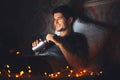 Night portrait of young smiling man lying on pillow on bed in dark room at home, holding reusable aluminum thermo water bottle. Royalty Free Stock Photo