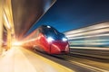 Night railway station, a passing train at speed. Modern travel technology Royalty Free Stock Photo