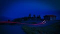 Night road leading to a small house and red lines from a long exposure Royalty Free Stock Photo