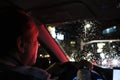 Night road. View from inside car. Natural light. the man driving a car at night in the face reflects the red color of the parking Royalty Free Stock Photo