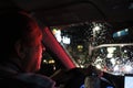 Night road. View from inside car. Natural light. the man driving a car at night in the face reflects the red color of the parking Royalty Free Stock Photo