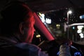 Night road. View from inside car. Natural light. the man driving a car at night in the face reflects the red color of the parking Royalty Free Stock Photo