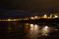 Night rocky sea coast and city lights Royalty Free Stock Photo