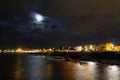 Night rocky sea coast and city lights Royalty Free Stock Photo