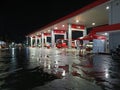 Night\'s Glow: Reflections at a Rain-Kissed Gas Station