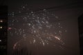 Night salute. Explosion lines of different colors. Outbreaks between houses Royalty Free Stock Photo