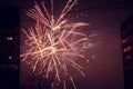 Night salute. Explosion lines of different colors. Outbreaks between houses Royalty Free Stock Photo