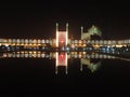 The night scene of brightly light up Shah Mosque and arcade shop bazaar with reflection in pool at Naqah-e Jahan Square.