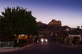 Night scene in the city of Sedona. Cars and shops in the foreground and a view of the mountains in the background