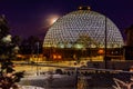 Night scene of the Desert Dome, with the full moon riding on the left side, at Henry Doorly Zoo Omaha Nebraska. Royalty Free Stock Photo