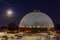 Night scene of the Desert Dome, with the full moon riding on the side, at Henry Doorly Zoo Omaha Nebraska. Royalty Free Stock Photo
