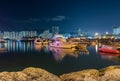 Night scene of Fishing village a small community with fishing boats and night cityscape at Lei Yue Mun water bay