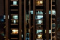 Night scene - front view of high-rise building with windows of apartments in which light is burning.