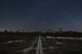 Night scene, landscape astrophoto at Seli swamp, wooden path for travelers on foot and starry sky Royalty Free Stock Photo