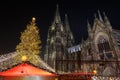 Night scenery and low angle view of huge Christmas tree and Cologne Cathedral during Christmas Market .