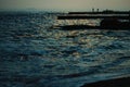 Night seashore with moonlight on the water and silhouettes of piers Royalty Free Stock Photo