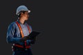 Night shift engineer technician male in safety hardhat hand holding tablet at night time isolated with clipping path Royalty Free Stock Photo