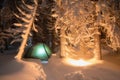 Night shot of burning fire, long exposure, sleeping in the snow outside. Night bivouac in the mountains. Christmas time. Royalty Free Stock Photo