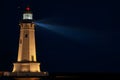 Night shot of lighthouse with illuminated beam piercing the darkness Royalty Free Stock Photo